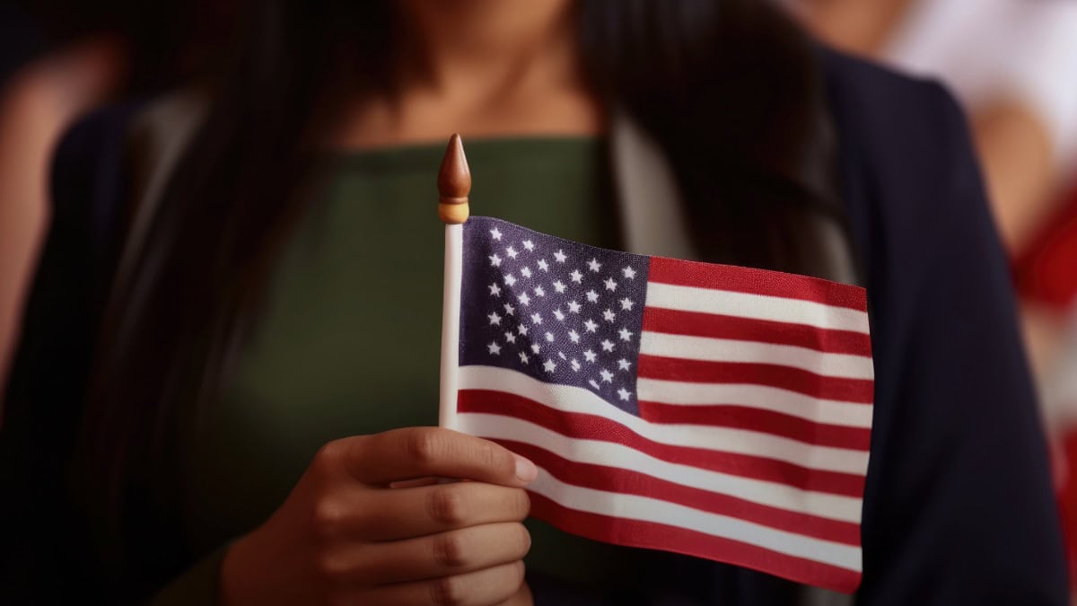 Persona con traje sostiene bandera de Estados Unidos en evento público. — memphisnoticias.com